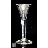 An 18th Century drinking glass circa 1750, the trumpet bowl above a teared plain stem, raised to a