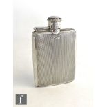 A hallmarked silver small hip flask with engine turned decoration to whole and terminating in hinged