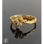 An early 20th Century 18ct diamond two stone cross over ring, millgrain set stones to feather