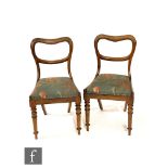 A set of four Victorian rosewood balloon back dining chairs with drop-in floral upholstered seats