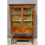 An early 20th Century mahogany bow-fronted side display cabinet, with cornice pediment above bar