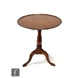 A 19th Century circular mahogany tilt top tripod occasional table on ring turned baluster pedestal