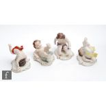 Four later 20th Century German models of cherubs each in a playful pose with green, red, yellow