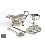 Five items of hallmarked silver, a sauce boat, bon bon dish, a small trophy, an embossed spoon and a