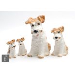 A graduated set of four Sylvac dogs in white with brown painted features, all with impressed