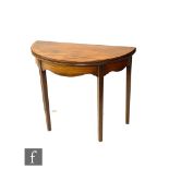 A George III mahogany fold-over tea table of circular form, with a cross-banded border above a