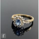 A 9ct sapphire and diamond cluster ring, central sapphire within a twelve stone diamond border and