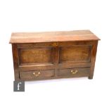 An 18th Century oak mule chest the twin plank hinged top over a panel drawer front on stiles, height