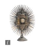 An 18th Century or earlier miniature gilt metal monstrance, the centre inset with a raised crystal