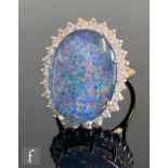 An 18ct hallmarked opal triplet and diamond cluster ring, central opal triplet, length 18mm, claw