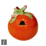 A Clarice Cliff preserve pot and cover in the shape of an orange, circa 1930, hand painted with