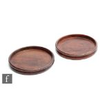 A pair of 19th Century turned mahogany coasters with raised edges, diameter 15cm. (2)