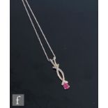 A 9ct hallmarked white gold ruby and diamond contemporary pendant, single pear cut ruby below a