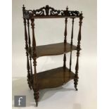 A Victorian rosewood three-tier serpentine-fronted whatnot, with pierced acanthus scroll gallery