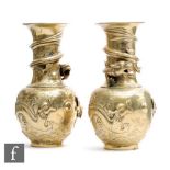 A pair of Chinese 20th Century cast polished metal vases, each of bottle form, cast in relief with