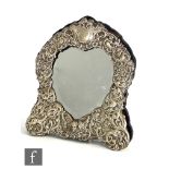 A modern hallmarked silver mounted heart shaped easel mirror decorated with embossed foliate