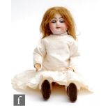 An unmarked bisque socket head doll, with sleeping blue eyes, open mouth with integral teeth, and