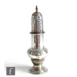 A George III hallmarked silver sugar castor of plain baluster form, plain body below pierced cover