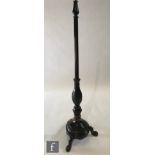 An Edwardian mahogany standard lamp, turned tapering reeded and leaf carved column and splayed