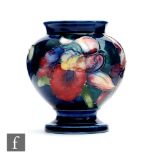 A small Moorcroft vase of footed bulbous form decorated in the Frilled Orchid pattern, any marks