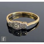 A mid 20th Century 18ct diamond three stone ring, to knife edged shoulders, weight 2.1g, ring size