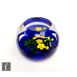 A later 20th Century Caithness paperweight, with a lamp worked yellow floral design contained in a
