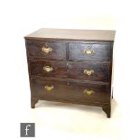An early 20th Century oak chest of two short and two long drawers, brass fret drop handles, on