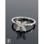 A contemporary 18ct hallmarked white gold four stone diamond cluster ring, four radiating marquise