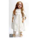 An unmarked German bisque socket head doll, with sleeping brown eyes, open mouth with teeth and