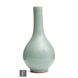 A Chinese celadon glazed bottle vase, the low half glazed footring gently sloping to a cylindrical