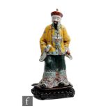 A Chinese Republic Period (1912-1944) porcelain figure of an official, dressed in formal robes,