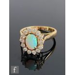 A 14ct opal and diamond cluster ring, central claw set oval opal within a fourteen stone brilliant