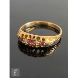 An early 20th Century 18ct ruby and diamond five stone boat shaped ring all to reeded shoulders,
