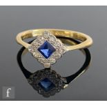 An early 20th Century 18ct sapphire and diamond cluster ring, central off set square sapphire within