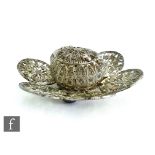 A white metal filigree circular pomander to a conforming six petal stand, diameter 10cm.