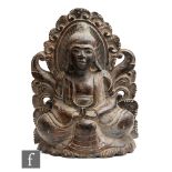 A South-East Asian carved wooden figure of Buddha seated in lotus position on a carved ruyi