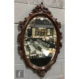 A contemporary reproduction hardwood framed oval wall mirror in the Victorian style, height 90cm and