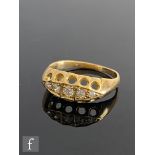 An early 20th Century 18ct diamond five stone boat shaped ring, graduating stones to plain