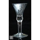 An 18th Century wine glass circa 1720, the waisted bell bowl with solid base above a plain teared
