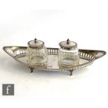 A hallmarked silver desk set of elongated oval form with raised pierced gallery supporting twin