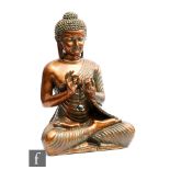 A South East Asian carved patinated wooden figure of Shakyamuni Buddha, eyes downcast in