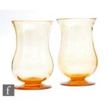 A pair of late 19th to early 20th Century glass vases, of waisted footed form, with subtle ribbed