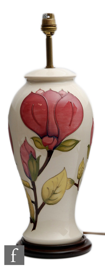 A large Moorcroft Pottery lamp base decorated in the Magnolia pattern with pink flowers against a