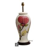 A large Moorcroft Pottery lamp base decorated in the Magnolia pattern with pink flowers against a
