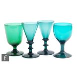 A pair of early 19th Century green wine glasses circa 1815, the drawn funnel bowls on an angular