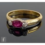 A modern 18ct hallmarked three stone ruby and diamond ring, central oval ruby flanked with diamond