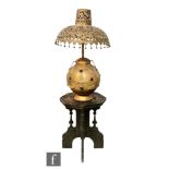 A Tibetan gilt metal lamp base of rounded form, applied with relief Buddha figures and 'jewels',