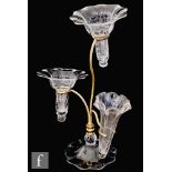 A late Victorian glass epergne with two wrythen and one slender ribbed trumpet form posy vases,