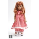 A Trendon Sasha redhead doll, wearing a handmade red and white striped dress with matching trousers,