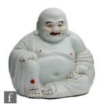 A Chinese porcelain laughing Buddha figure, in seated position with smiling face, picked out with